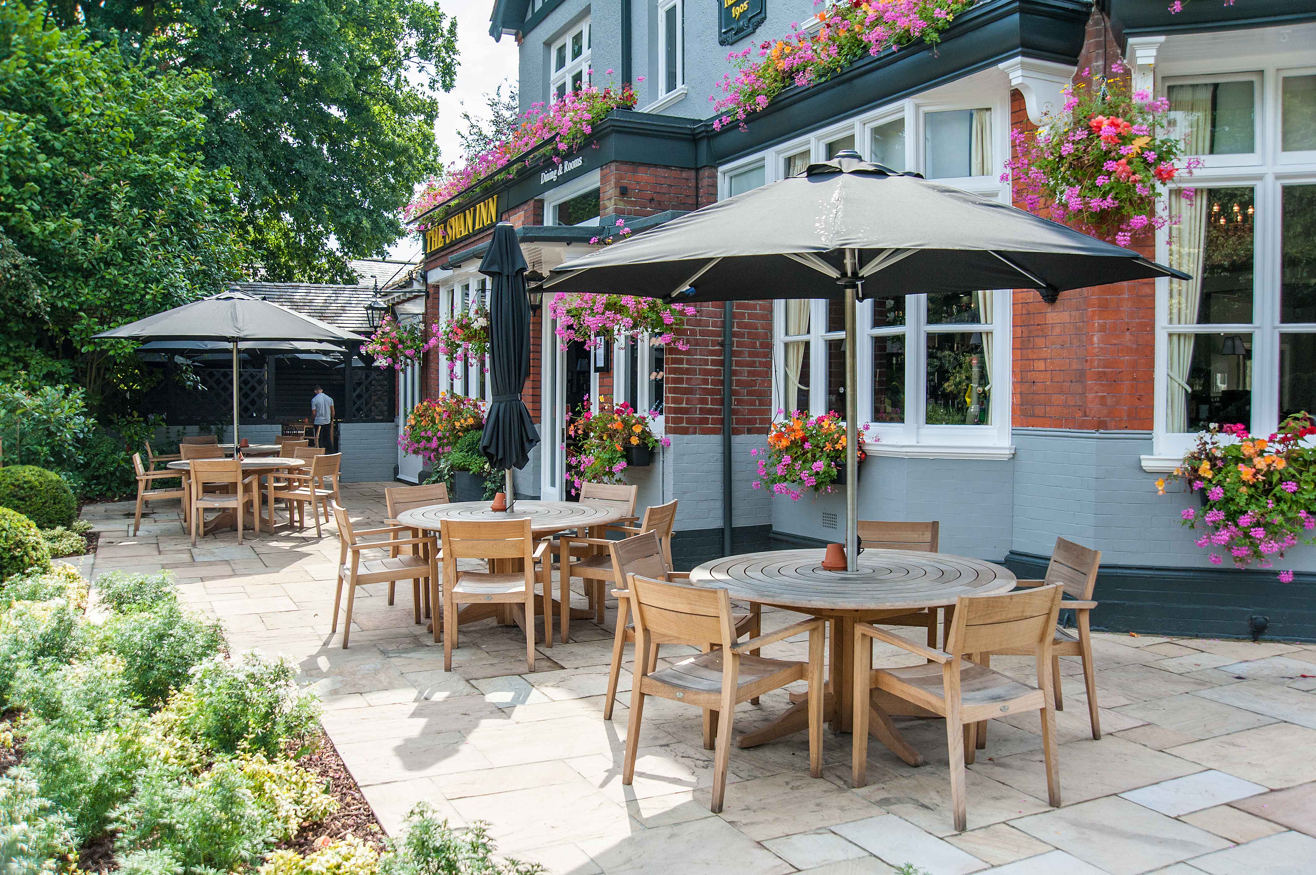 Alexander Rose commercial round tables and chairs with black parasol at Cowdrey in a pub setting
