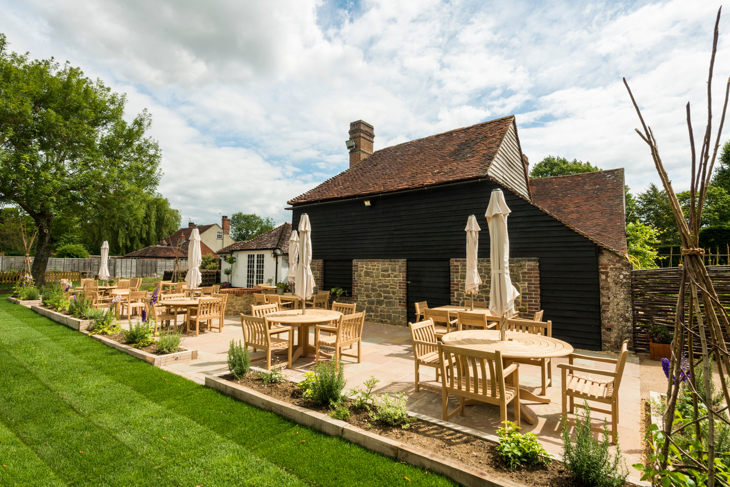 Roble circular tables and chairs with fitted parasol in a pub garden setting