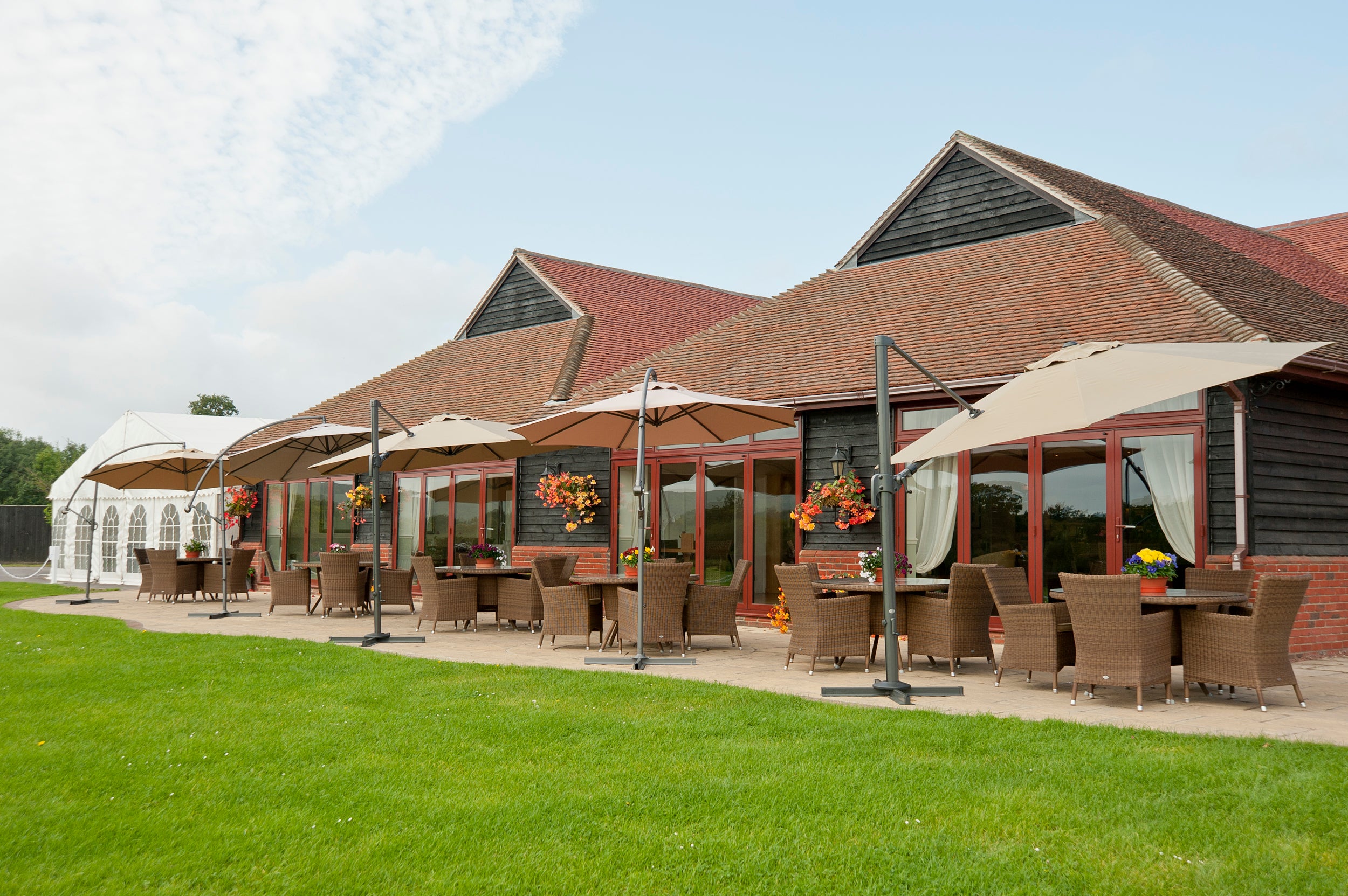 Alexander Rose Commercial weaved chairs glass tables and parasols at Mid Sussex Golf Club