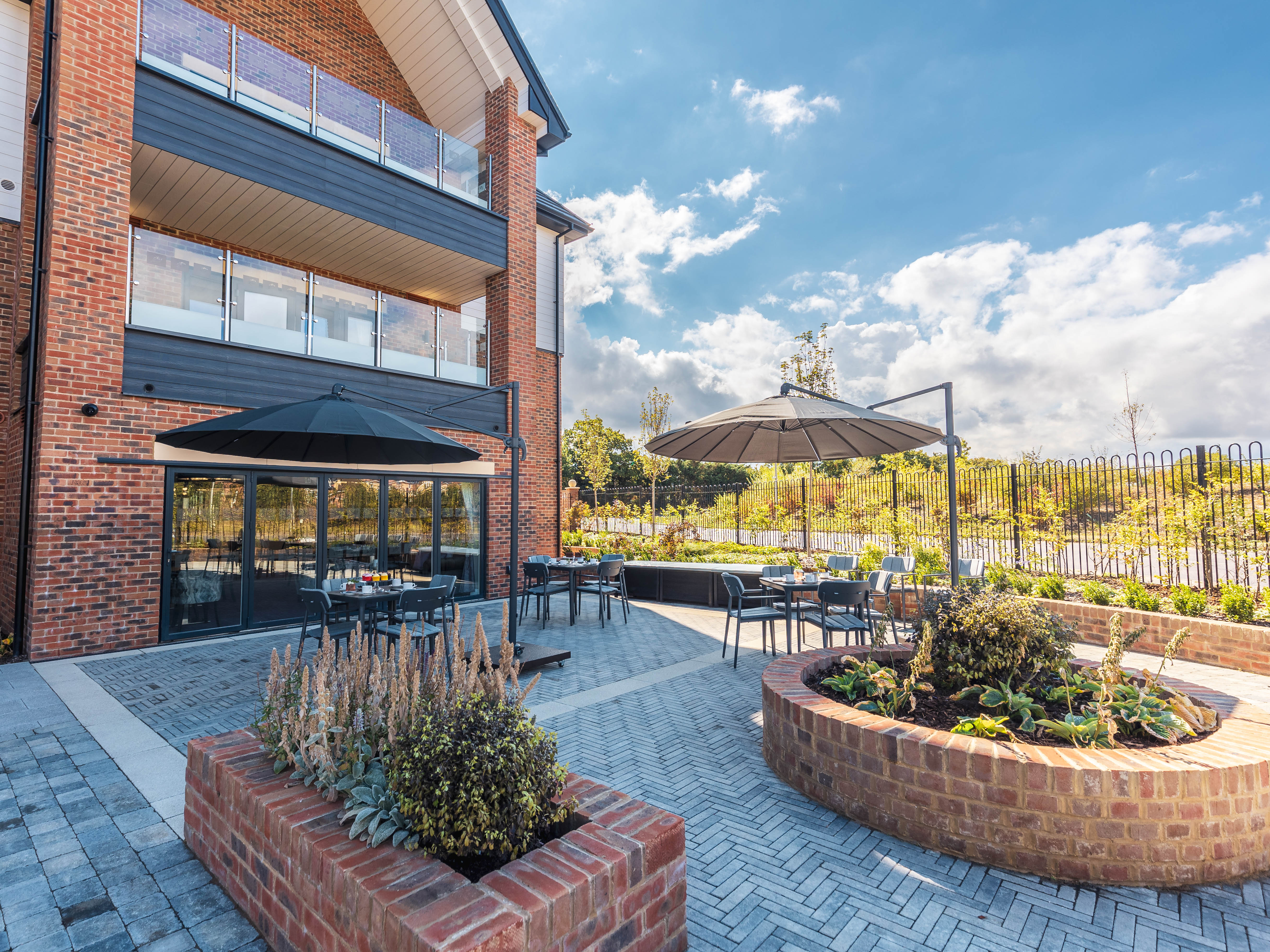 Barchester care home outdoor setting with Alexander Rose Commercial rimini furniture and parasols