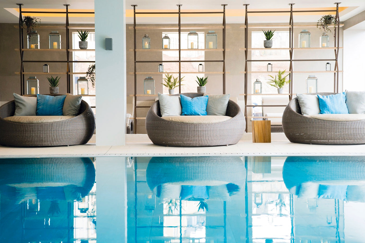 indoor swimming pool showing luxurious circular day beds with scatter cushions